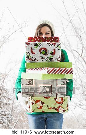 Caucasian woman holding Christmas gifts in snow View Large Photo Image Stock Photograph - Caucasian woman holding Christmas gifts in snow. Fotosearch