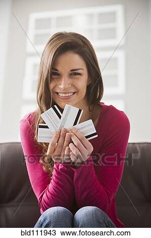Stock Image - Caucasian woman holding credit cards. Fotosearch