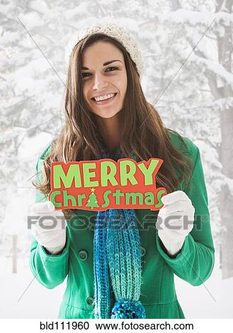 Caucasian woman holding 'Merry Christmas' sign in snow View Large Photo Image Stock Image - Caucasian woman holding 'Merry Christmas' sign in snow. Fotosearch