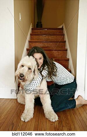 Stock Photograph - Caucasian woman hugging dog by steps. Fotosearch