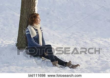 Stock Photo - Caucasian woman sitting in snow. Fotosearch