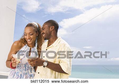 Couple having drinks on balcony View Large Photo Image Stock Photography - Couple having drinks on balcony. Fotosearch