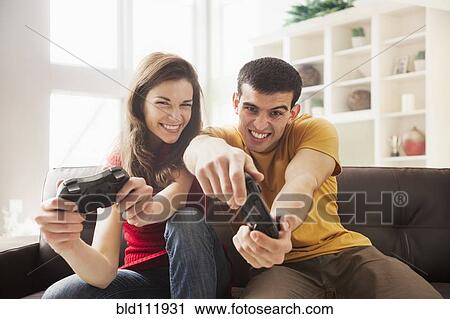 Stock Image - Couple playing video games together. Fotosearch