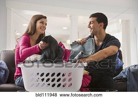 Couple sorting laundry together View Large Photo Image Stock Photo - Couple sorting laundry together. Fotosearch