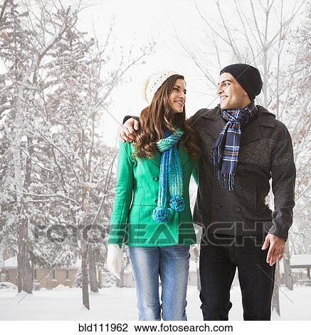 Stock Image - Couple walking together in snow. Fotosearch