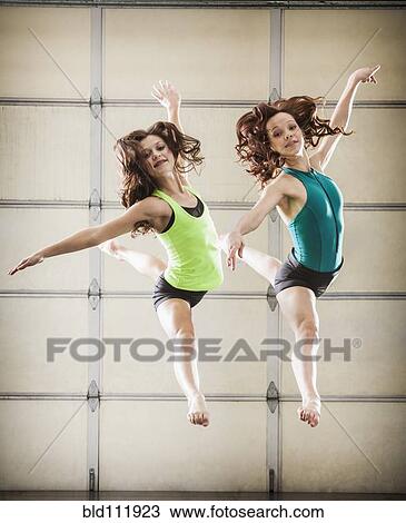 Stock Image - Dancers leaping in studio. Fotosearch