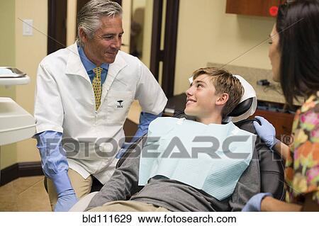 Dentist and nurse talking to patient View Large Photo Image Stock Photo - Dentist and nurse talking to patient. Fotosearch