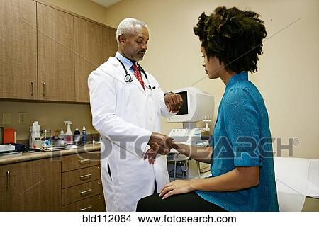 Doctor checking patient's pulse in office View Large Photo Image Picture - Doctor checking patient's pulse in office. Fotosearch
