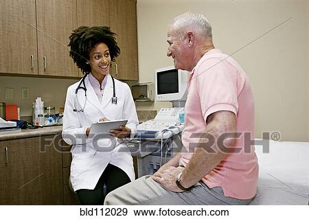 Doctor talking to patient in office View Large Photo Image Stock Photo - Doctor talking to patient in office. Fotosearch