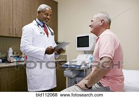 Doctor talking to patient in office View Large Photo Image Stock Photo - Doctor talking to patient in office. Fotosearch