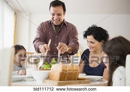 Family eating together at table View Large Photo Image Stock Image - Family eating together at table. Fotosearch