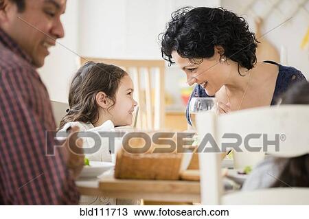 Family eating together at table View Large Photo Image Stock Image - Family eating together at table. Fotosearch