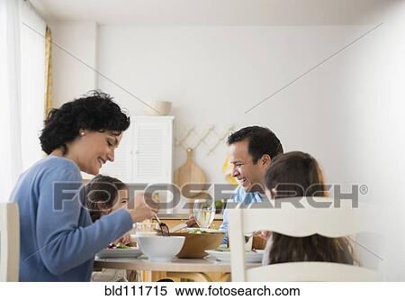 Family eating together at table View Large Photo Image Stock Photography - Family eating together at table. Fotosearch