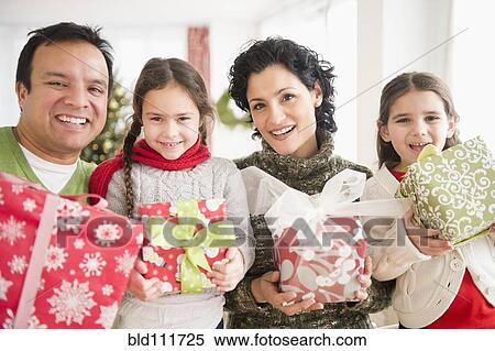 Stock Photography - Family holding Christmas presents. Fotosearch