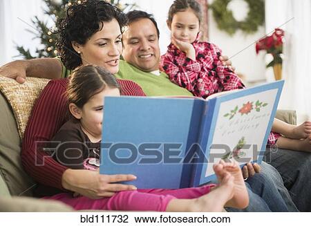 Stock Image - Family reading together on sofa. Fotosearch