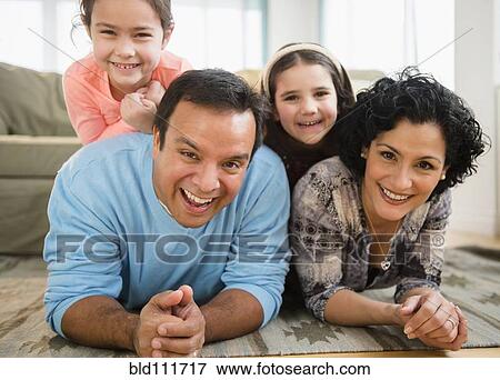 Stock Photo - Family relaxing together in living room. Fotosearch