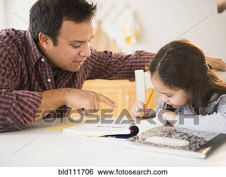 Stock Photograph - Father helping daughter with homework. Fotosearch
