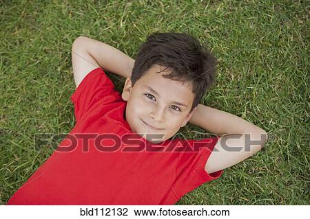 Hispanic boy laying in grass View Large Photo Image Stock Image - Hispanic boy laying in grass. Fotosearch