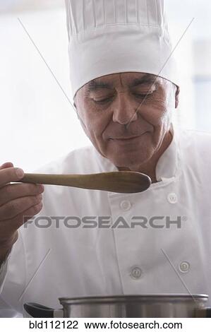 Hispanic chef tasting food in kitchen View Large Photo Image Stock Image - Hispanic chef tasting food in kitchen. Fotosearch