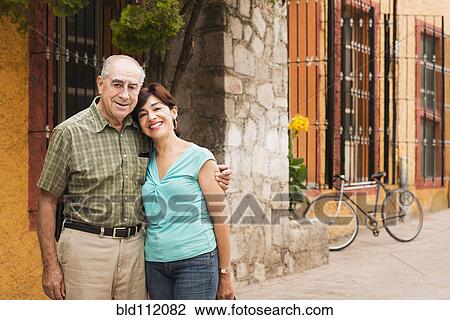 Stock Image - Hispanic couple smiling on city street. Fotosearch