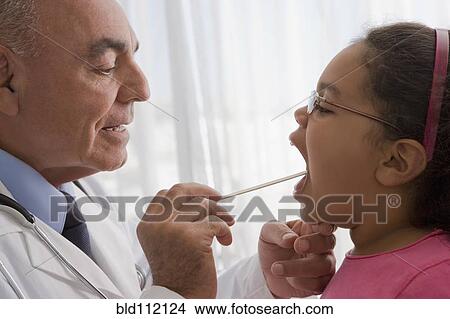 Hispanic doctor checking patient's throat View Large Photo Image Picture - Hispanic doctor checking patient's throat. Fotosearch