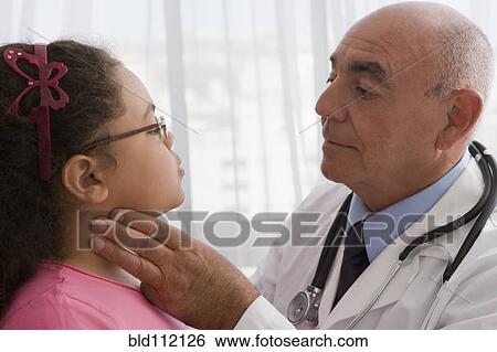 Stock Photograph - Hispanic doctor checking patient's throat. Fotosearch