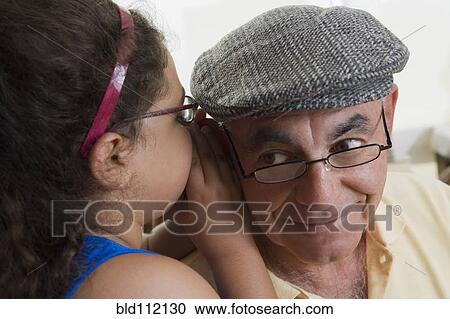 Hispanic girl whispering to grandfather View Large Photo Image Stock Image - Hispanic girl whispering to grandfather. Fotosearch