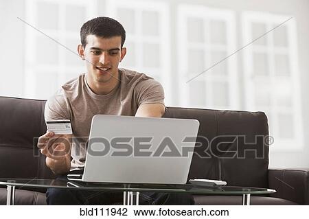 Stock Image - Hispanic man shopping online. Fotosearch