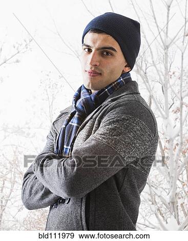 Stock Photo - Hispanic man standing in snow. Fotosearch