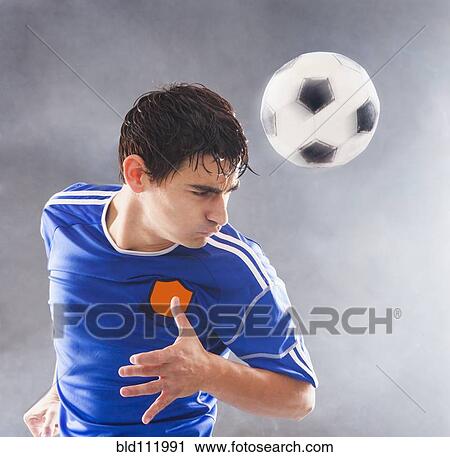 Stock Image - Hispanic soccer player hitting ball with head. Fotosearch