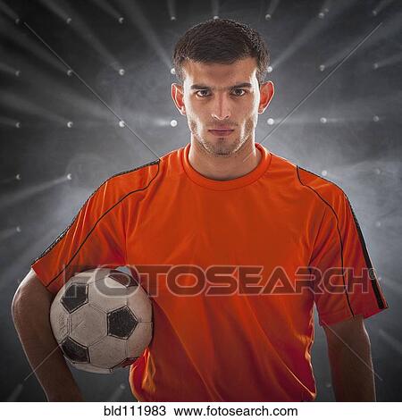 Stock Image - Hispanic soccer player holding ball. Fotosearch