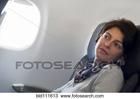 Hispanic woman sitting in airplane View Large Photo Image Stock Image - Hispanic woman sitting in airplane. Fotosearch