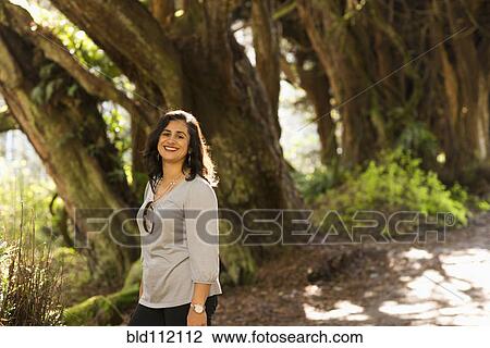 Stock Image - Hispanic woman walking outdoors. Fotosearch