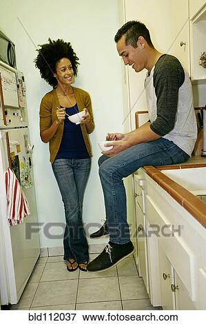 Mixed race couple relaxing in kitchen View Large Photo Image Stock Photo - Mixed race couple relaxing in kitchen. Fotosearch