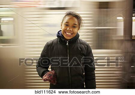 Picture - Mixed race girl smiling in subway station. Fotosearch