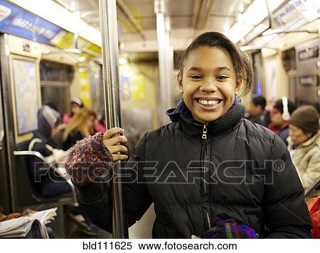 Mixed race girl smiling on subway View Large Photo Image Stock Photography - Mixed race girl smiling on subway. Fotosearch