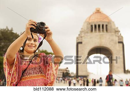 Stock Photo - Mixed race girl taking pictures on city street, Mexico City, Federal District, Mexico. Fotosearch
