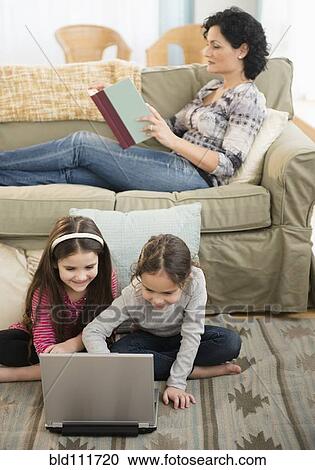 Mother and daughters relaxing in living room View Large Photo Image Stock Image - Mother and daughters relaxing in living room. Fotosearch