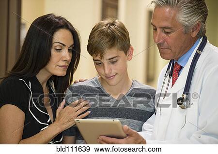 Stock Photo - Mother and son using digital tablet with dentist. Fotosearch