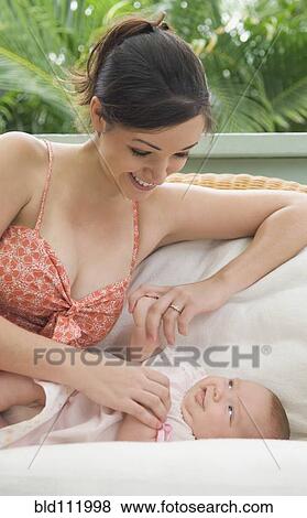Mother playing with baby on sofa View Large Photo Image Stock Photo - Mother playing with baby on sofa. Fotosearch
