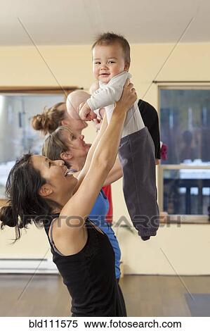 Stock Photography - Mothers and babies taking yoga class. Fotosearch
