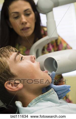 Picture - Nurse using equipment on dental patient. Fotosearch