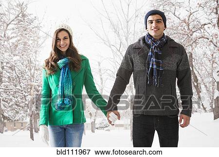 Stock Photo - Smiling couple holding hands in show. Fotosearch
