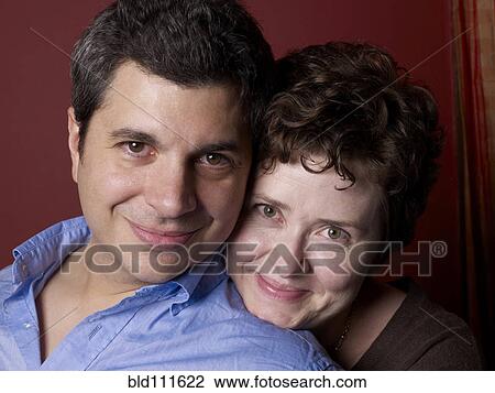 Smiling couple hugging indoors View Large Photo Image Stock Image - Smiling couple hugging indoors. Fotosearch