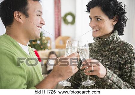Stock Photograph - Smiling couple toasting each other with champagne. Fotosearch