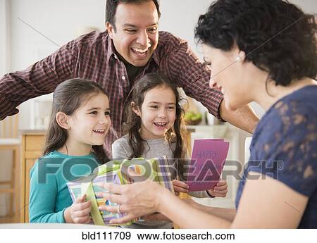 Stock Photo - Smiling family celebrating girl's birthday. Fotosearch