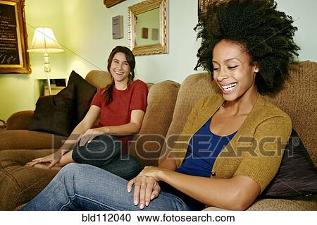 Women relaxing on sofa View Large Photo Image Stock Image - Women relaxing on sofa. Fotosearch