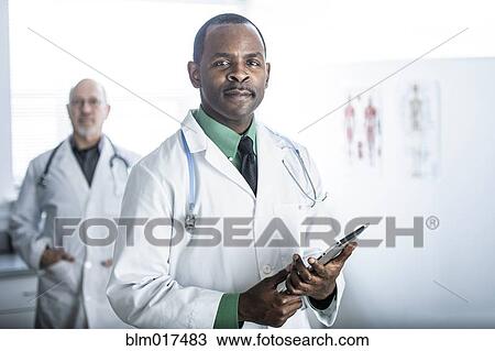 Stock Image - African American doctor standing in office. Fotosearch
