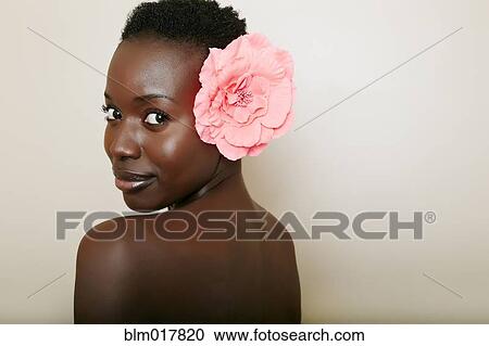 Stock Image - African American woman wearing flower in hair. Fotosearch