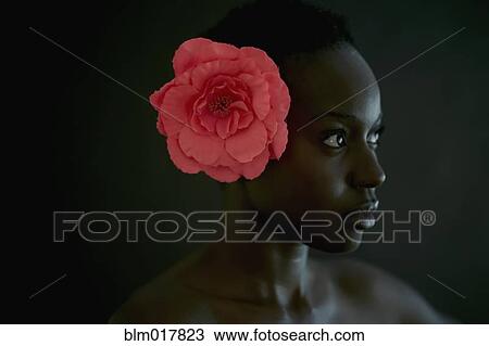 Stock Image - African American woman wearing flower in hair. Fotosearch